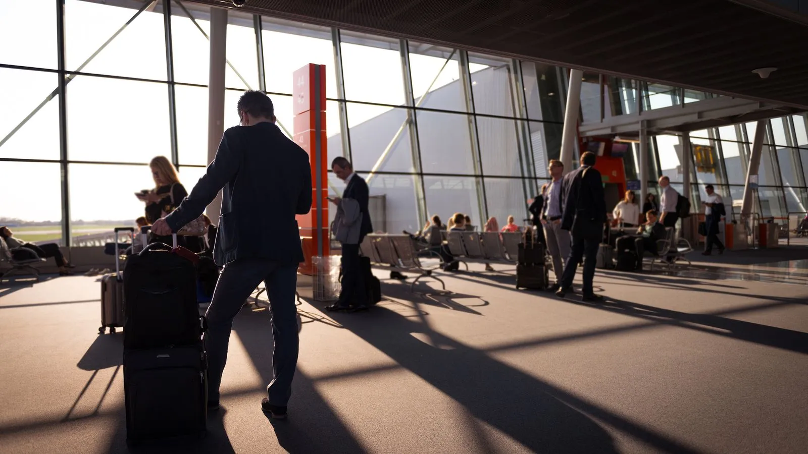 Voyageurs d'affaires avec bagages cabine dans un terminal d'aéroport