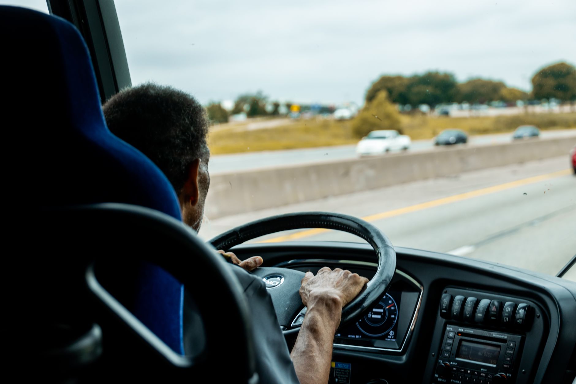 chauffeur d'autocar au volant sur une voie rapide, vu depuis l'intérieur du véhicule