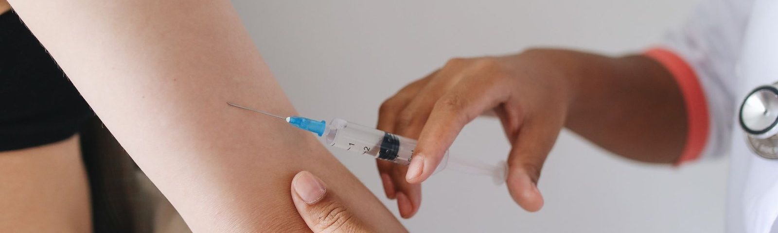 Professionnel de santé réalisant une injection de vaccin avant un départ