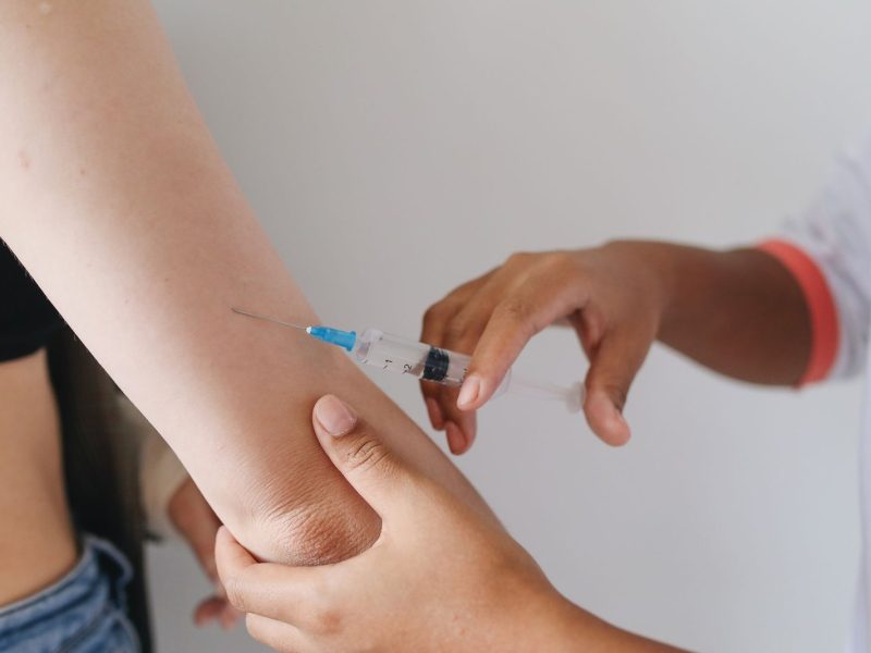 Professionnel de santé réalisant une injection de vaccin avant un départ