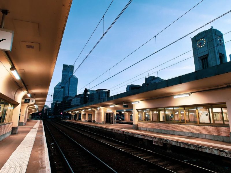Quai de gare à Bruxelles au crépuscule, avec la tour de l'horloge