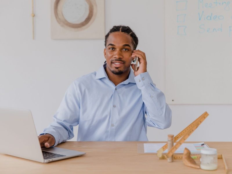 Dirigeant de PME au téléphone devant son ordinateur portable, au bureau