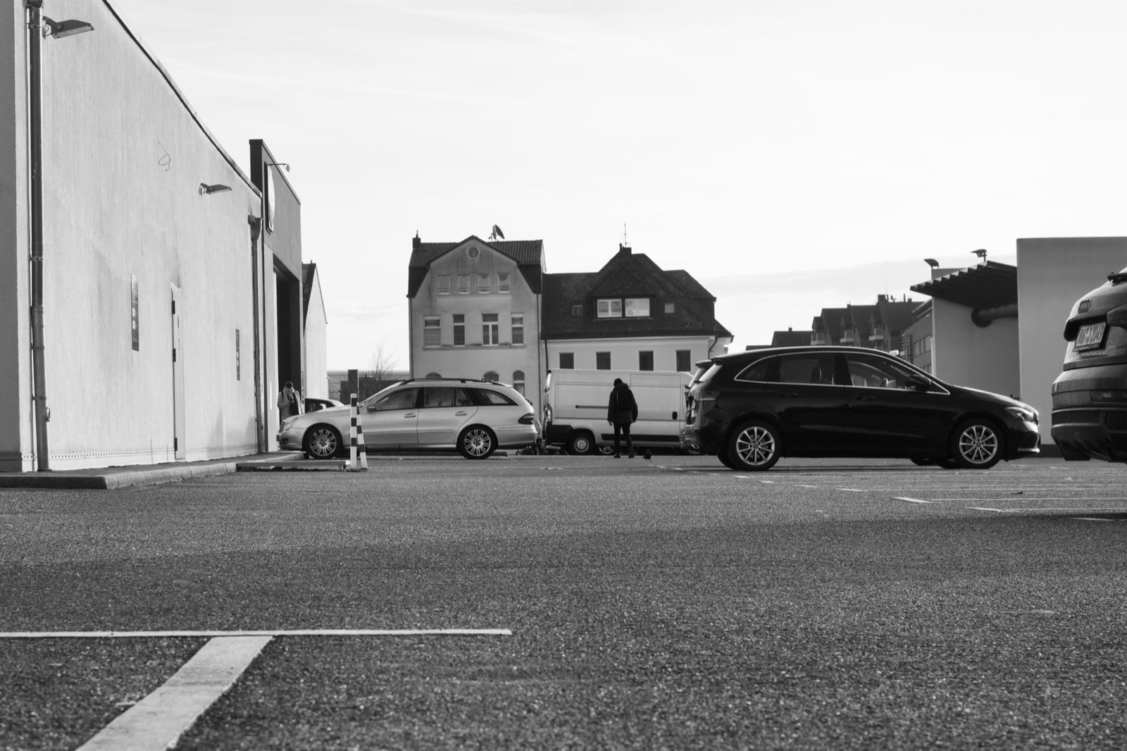 Collaborateurs en covoiturage devant des véhicules d'entreprise sur un parking