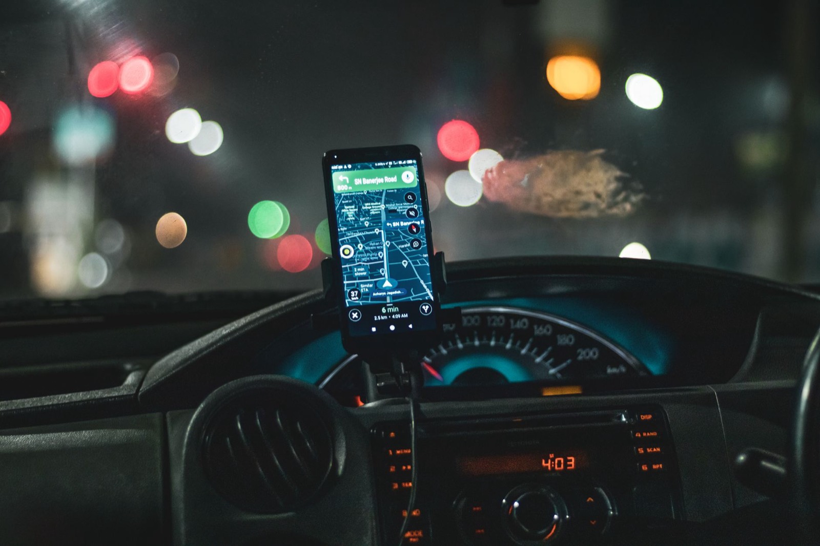 application de covoiturage sur un smartphone posé sur le tableau de bord d'une voiture