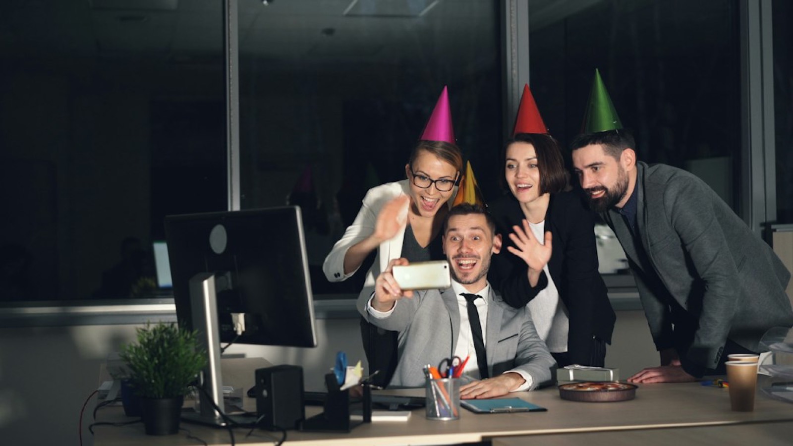 Collègues réunis autour d'un gâteau d'anniversaire au bureau