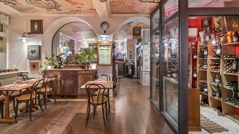 Salle intérieure avec tables dressées, bar en bois et cave à vin visible au fond