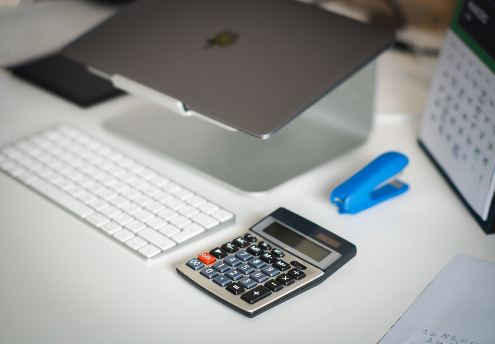 Calendrier, calculatrice et ordinateur portable sur un bureau pour calculer la prolongation d'un bail